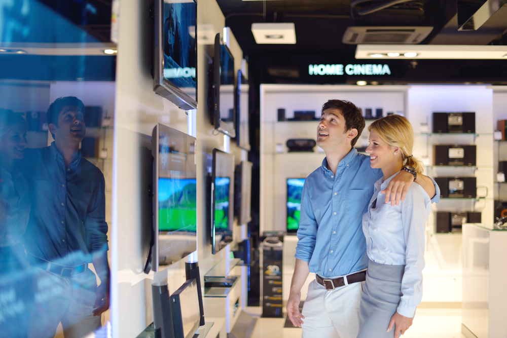 people in consumer electronics  retail store looking at latest laptop, television and photo camera to buy-1